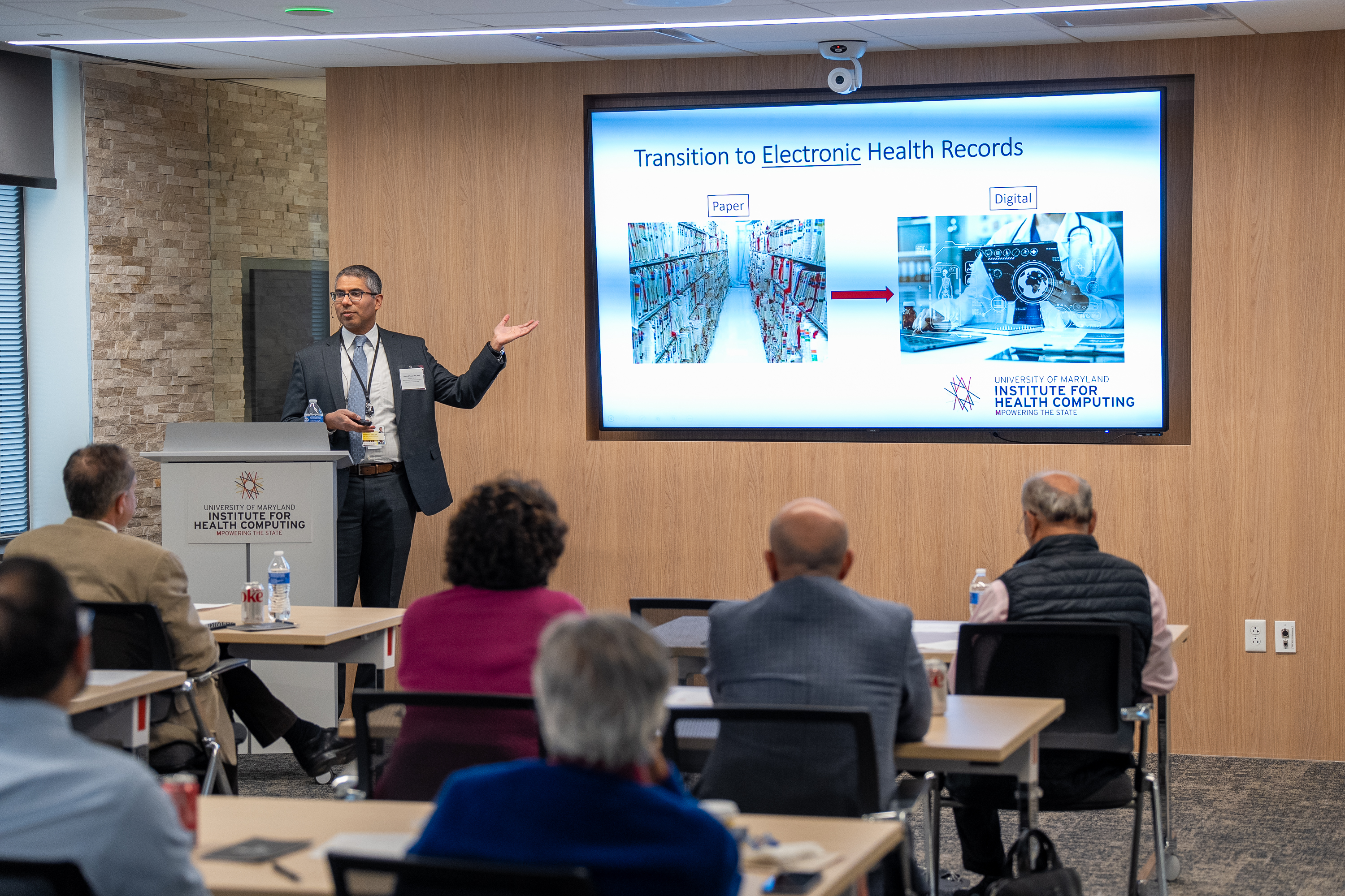 Photo of Warren D'Souza pointing to the presentation screen.