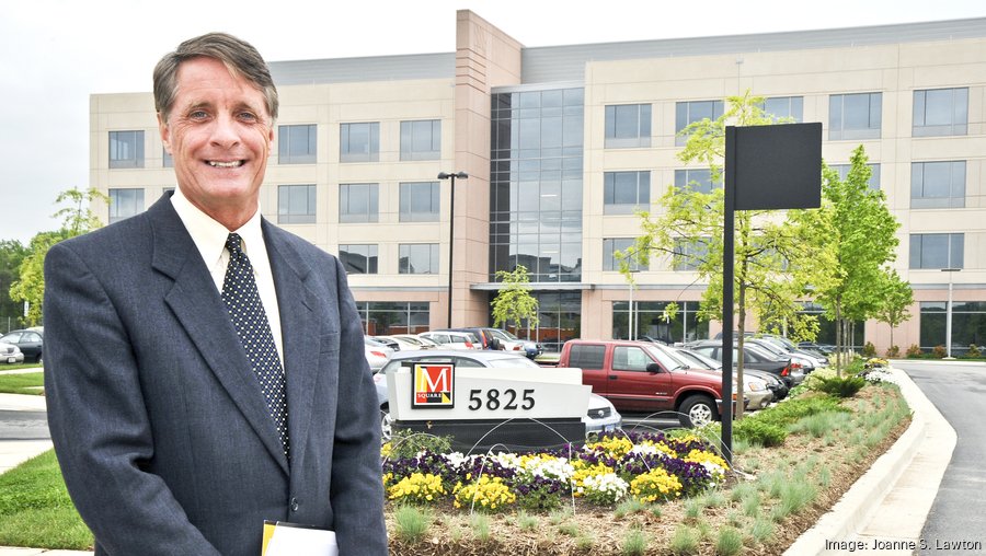Photo of male in front of a building in parking lot