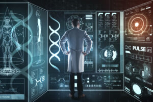 Male in a white lab coat stands in front of large digital screens displaying medical data.