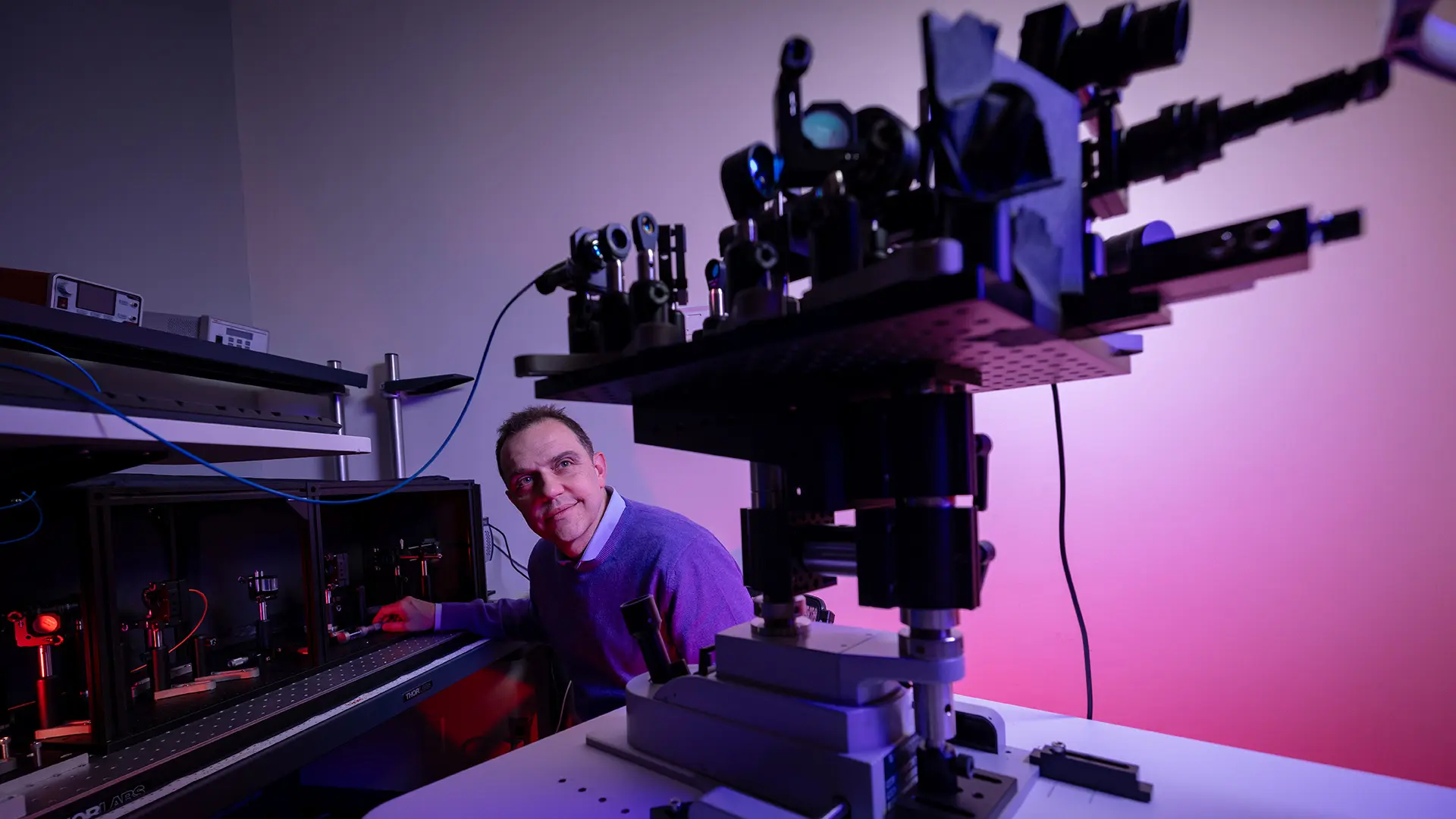 Photo of Guliano Scarcelli in front of high-tech ophthalmic equipment.